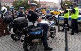 Na zdjęciu widać czterech funkcjonariuszy Wydziału Ruchu Drogowego dwóch siedzi na motocyklach służbowych dwóch w żółtych kamizelkach z napisem POLICJA stoi obok służbowgo radiowozu oznakowanego