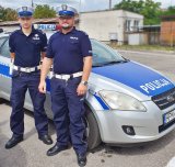 Policjanci z Wydziału Ruchu Drogowego Komendy Miejskiej Policji w Łomży na tle radiowozu