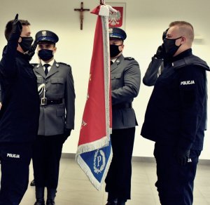 Na zdjęciu widać czterech policjantów dwóch stojących ze sztandarem i dwóch po przeciwnej stronie sztandaru