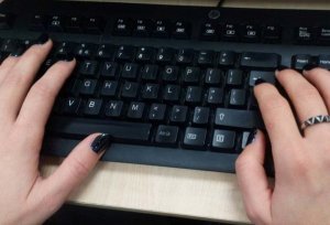 Dwie kobiece dłonie piszące na klawiaturze komputera