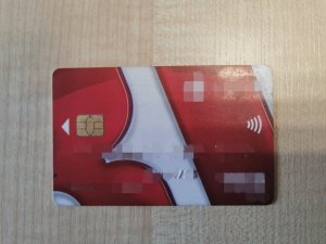 Karta bankomatowa koloru czerwono białego.