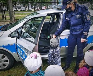 Policjantka przy radiowozie na spotkaniu z dziećmi