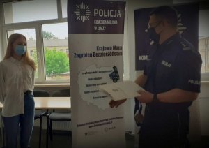 Policjant wręczający dyplom dziewczynce