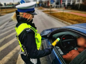 Umundurowana policjantka bada trzeźwość kierowcy