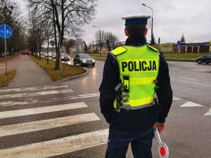 Umundurowany policjant stoi przy przejściu dla pieszych