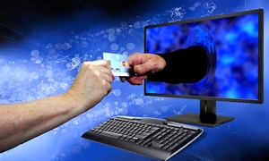 Ręka wychodząca z komputera bierze pieniądze od mężczyzna siedzącego przed komputerem