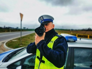Policjant mierzy prędkość jadącym samochodom