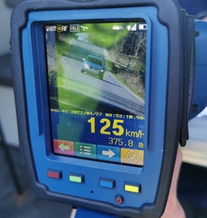 Zdjęcie ekranu ręcznego miernika prędkości, na którym widać, że kierowca jedzie z prędkością 125 kilometrów na godzinę.