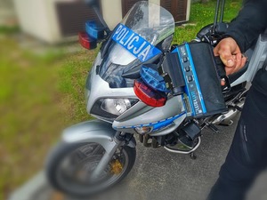 Ręczny miernik prędkości i w tle policyjny motocykl