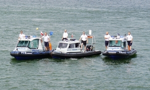 Trzy policyjne łodzie na tafli jeziora