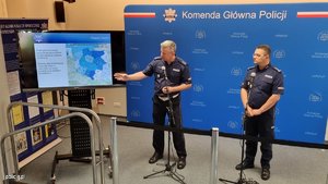 Dwóch policjantów przy planszy z mapą Polski