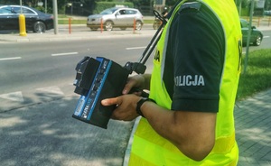 Policjant trzymający w ręku ręczny miernik prędkości