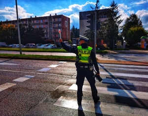 Policjant daje sygnał tarczą do zatrzymania samochodu do kontroli drogowej