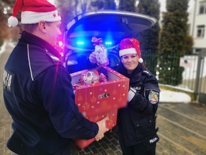 Policjanci trzymają prezenty dla dzieci