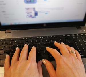 Kobiece dłonie piszące na klawiaturze komputera