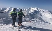 Policjanci w kombinezonach narciarskich i w nartach na stoku