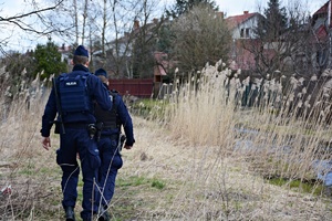 Policjanci idą polną ścieżką