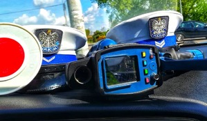czapki policjantów i urządzenie do pomiaru prędkości