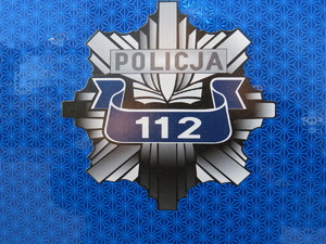 gwiazda policyjna z numerem 112 na niebieskim tle